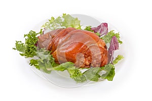 Boiled-smoked pork knuckle on the lettuce leaves on dish