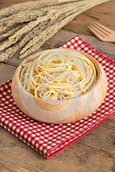 Boiled spaghetti in wood bowl.