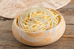 Boiled spaghetti in wood bowl.