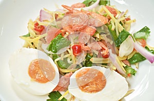 Boiled spicy salty egg half cut with dry shrimp and ginger salad on plate
