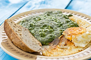 Boiled spinach with fried egg and a slice of bread