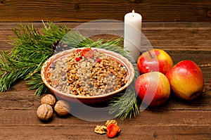 Boiled wheat - a traditional Christmas treat of the Slavs on Christmas Eve kutia. Fur-tree branch, apple, candle on a wooden backg