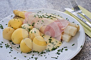 Boiled white asparagus with the ham and fresh new boiled potatoes served with the hollandaise sauce.