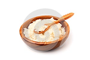 Boiled white rice in a wooden plate with wooden spoon.