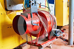 Boiler room with four large yellow cauldrons and red-blue burners.