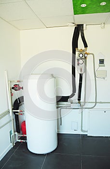 Boiler room with solar water heater tank for house energy efficiency. Modern gas boiler, heating electric warm water system