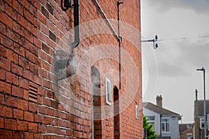 a boiler steam vent on the side of a brick house bellowing steam on a cold winter day