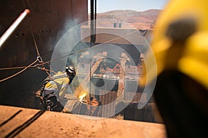 Boilermaker abseiler wearing safety harness, helmet commencing oxygen lancing