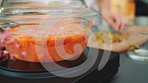 Boiling carrots in a glass bowl on a kitchen stove