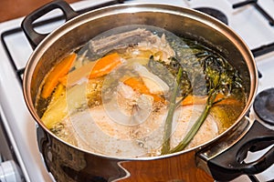 Boiling delicious chicken soup on gas stove