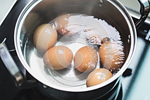 Boiling eggs or boiled egg cooking in hot water bowl