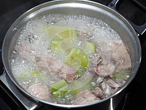 Boiling green bitter melon or bitter gourd with spareribs soup