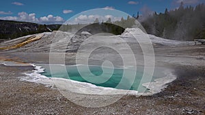 Boiling hot crystal clear water in a geyser. Yellowstone National park. Wyoming, USA