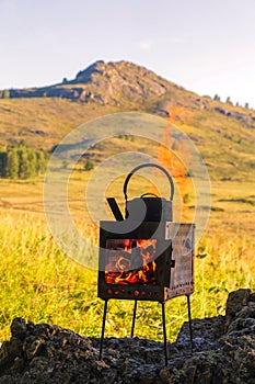 boiling kettle on a camp stove in the forest