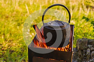 boiling kettle on a camp stove in the forest