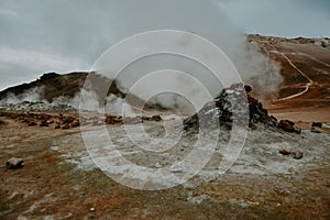 Boiling mudpots in the geothermal area Hverir and cracked ground around, Iceland in summer. Myvatn region,