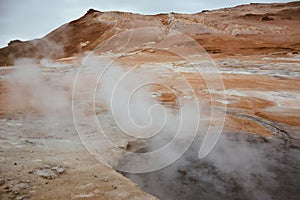 Boiling mudpots in the geothermal area Hverir and cracked ground around, Iceland in summer. Myvatn region, North part of Iceland