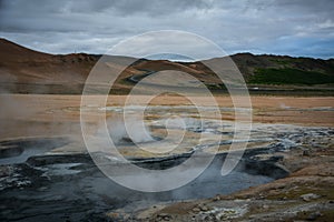 Boiling mudpots in the geothermal area Hverir and cracked ground around, Iceland in summer. Myvatn region, North part of Iceland