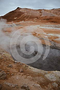 Boiling mudpots in the geothermal area Hverir and cracked ground around, Iceland in summer. Myvatn region, North part of Iceland