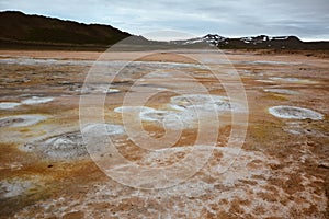 Boiling mudpots in the geothermal area Hverir and cracked ground around, Iceland in summer. Myvatn region, North part of Iceland