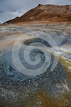 Boiling mudpots in the geothermal area Hverir and cracked ground around, Iceland in summer. Myvatn region, North part of Iceland