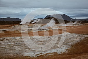 Boiling mudpots in the geothermal area Hverir and cracked ground around, Iceland in summer. Myvatn region, North part of Iceland