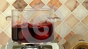 Boiling red Easter eggs in a glass pot