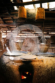 Boiling salt water in big jars with hanging salt in baskets