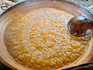 Boiling the sugarcane juice to make garapa, sugar and cachaÃÂ§a in a copper pot photo