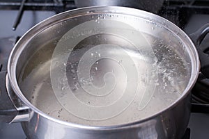 Boiling water in pan on stove in the kitchen