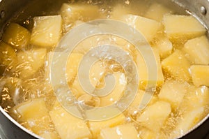 Boiling water and the process of making mashed potatoes. Bubbles of boiling liquid