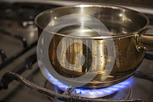 Boiling water in a steel casserole pot in a stove