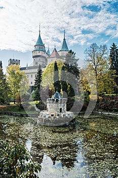 Bojnice castle with beautiful turret reflected in the lake, Slovak republic, seasonal scene