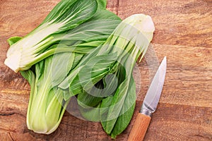 Bok choy or chinese cabbage on wooden background. View above