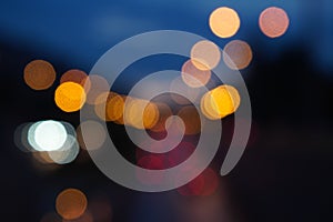 Bokeh abstract background of defocused city road traffic with car lights and street lamps at night