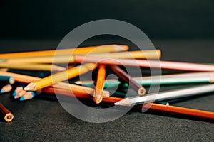 A bokeh of a bunch of colorful pencils lying on each other