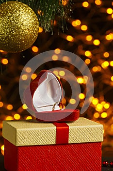 Bokeh Christmas background from gold garlands Christmas tree branch with a shiny ball under the Christmas tree gifts and