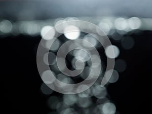 Bokeh lights on black background, shot of flying drops of water in the air, defocused water drops levitation on dark