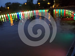 Bokeh lights of magic colorful illumination of pond in night