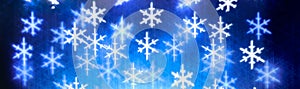 Bokeh of lights in the shape of white snowflakes abstract background