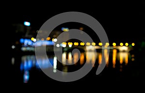 Bokeh of night river scene. Blur effect from the water and city lights in the background reflecting in the water. Defocused city