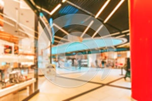 Bokeh Shopping mall background. Interior of retail centre store in soft focus. People shopping in modern commercial mall center.