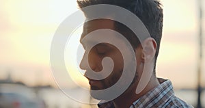 Bokeh shot of depressed young man standing outdoors on city street