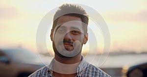 Bokeh shot of indian man smiling at camera standing on street in evening