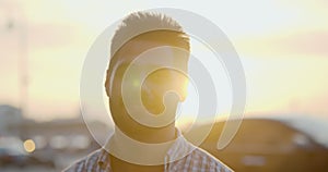 Bokeh shot of indian man smiling at camera standing on street in evening