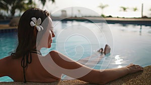 Bokeh Thai pool resort: woman rest in water. Pretty girl relax view: palm trees, beach and ocean bay