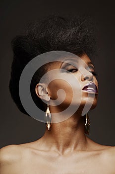 Bold African American woman with a fierce hairstyle and makeup