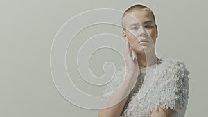 Bold caucasian beautiful female model in white clothes studio pose for light video portrait