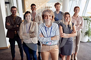 Bold and outgoing group of successful business people, looking at camera with team leader in front . eye contact