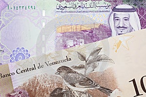 A bolivar note from Venezuela with a five riyal note from Saudi Arabia photo